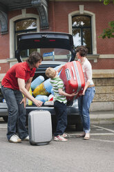 Germany, Leipzig, Family loading luggage into car - WESTF12170