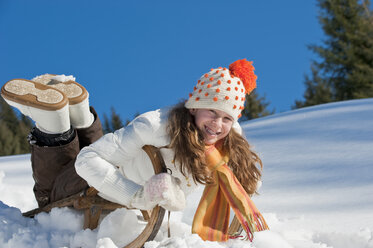 Austria, Salzburger Land, Altenmarkt, Girl (10-11) on sled, smiling, portrait - HHF03004
