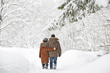 Austria, Salzburger Land, Altenmarkt, Couple walking in snow covered landscape, rear view - HHF02948