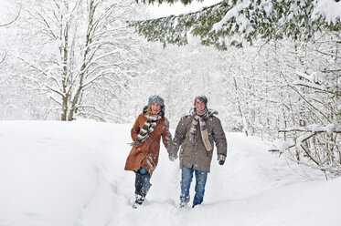 Austria, Salzburger Land, Altenmarkt, Couple walking in snow covered landscape - HHF02947