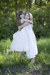 Germany, Bavaria, Two girls (8-9) embracing on meadow, portrait - MAEF01793