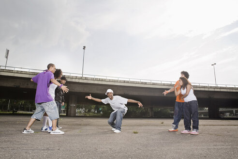 Germany, Cologne, Group of young people breakdancing on street - SK00041