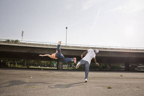 Deutschland, Köln, Junge Männer kämpfen auf einem Parkplatz, lizenzfreies Stockfoto