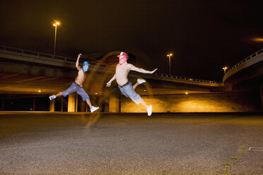 Germany, Cologne, Young people jumping, bridge in background - SK00018