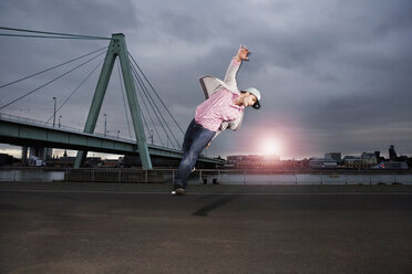 Deutschland, Köln, Junger Mann springt, Rheinbrücke im Hintergrund - SK00013