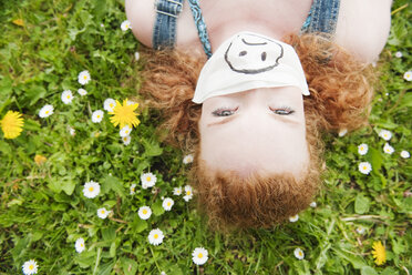 Germany, Bavaria, Young woman lying in meadow, elevated view - WESTF12244