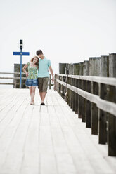 Germany, Bavaria, Ammersee, Couple walking across pier - WESTF12201