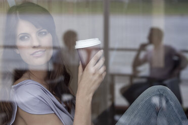 Deutschland, Köln, Junge Frau im Fenster eines Cafés - WESTF12365