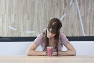 Germany, Cologne, Young woman sitting in cafe - WESTF12440