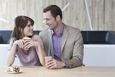 Germany, Cologne, Young couple in cafe, smiling, portrait - WESTF12432