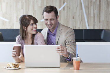 Germany, Cologne, Couple in cafe using laptop - WESTF12466