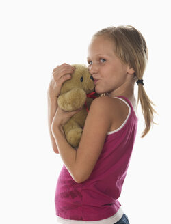 Portrait of girl (10-11) cuddling teddy bear, studio shot - WWF00974