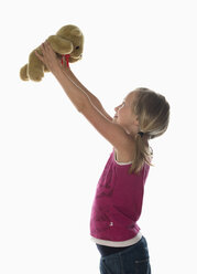 Girl (10-11) holding teddy, side view, portrait - WWF00972
