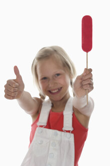 Girl (10-11) holding lollypop, rejoicing, thumbs up, portrait - WWF00953