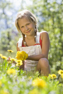 Österreich, Salzkammergut, Mädchen (10-11) beim Blumenpflücken, Porträt - WWF00948