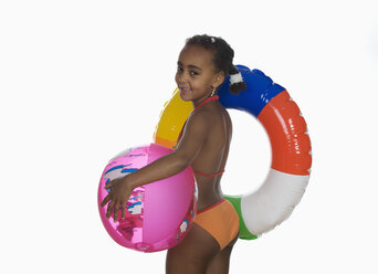 Afrikanisches Mädchen (6-7) hält Schwimmreifen und Strandball, Seitenansicht, Porträt - WWF00912