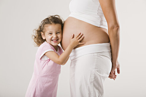 Mädchen (4-5) umarmt den schwangeren Bauch der Mutter - LDF00697