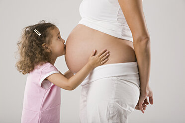 Mädchen (4-5) küsst den schwangeren Bauch der Mutter, Seitenansicht - LDF00696