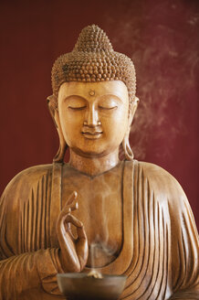 Buddha-Statue und eine Schale mit Räucherstäbchen - WESTF12490