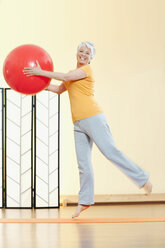 Ältere Frau hält Gymnastikball, Porträt - WESTF12479