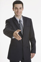 Geschäftsmann streckt seine Hand aus, lächelnd, Porträt - LDF00735