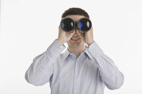 Businessman using binoculars, portrait stock photo