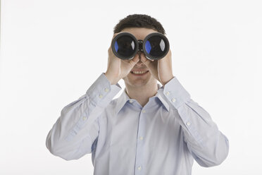 Businessman using binoculars, portrait - LDF00720