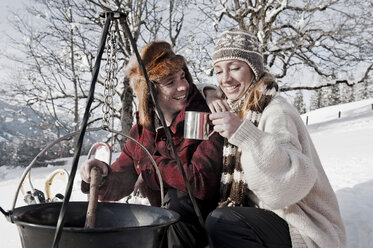 Österreich, Salzburger Land, Pärchen kocht am Lagerfeuer - HHF03047