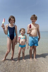 Spanien, Mallorca, Kinder halten Eis am Strand, lächelnd, Porträt - WESTF12710