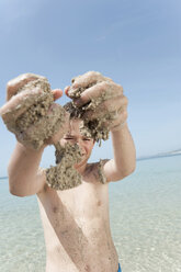 Spain, Mallorca, Boy (8-9) with sandy hands playing at the beach - WESTF12643