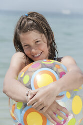 Spain, Mallorca, Girl (10-11) holding beachball, smiling, portrait - WESTF12620