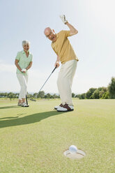 Spain, Mallorca, Senior couple on golf course, man cheering - WESTF12850