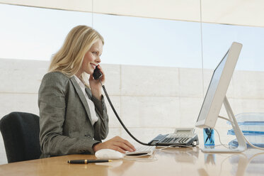 Young woman in office using phone - WESTF12840