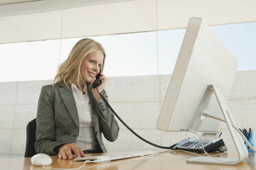 Young woman in office using phone - WESTF12839