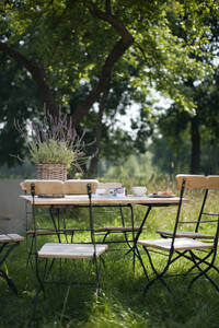 Germany, Hamburg, Empty chairs and table in garden - WESTF13050