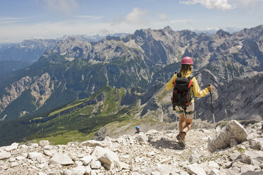 Germany, Garmisch-Partenkirchen, Alpspitz, Woman hiking, rear view - RNF00010