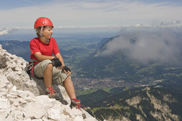 Deutschland, Garmisch-Partenkirchen, Alpspitz, Bergsteiger, Junge (12-13) auf dem Gipfel sitzend, Porträt - RNF00009