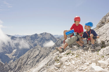 Deutschland, Garmisch-Partenkirchen, Alpspitz, Bergsteiger, Jungen (10-11), (12-13) sitzen auf Felsen - RNF00008