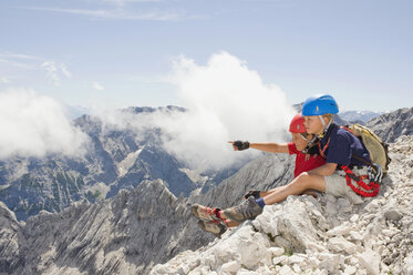 Deutschland, Garmisch-Partenkirchen, Alpspitz, Bergsteiger, Jungen (10-11), (12-13) sitzen auf Felsen - RNF00007