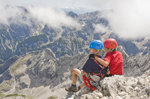 Deutschland, Garmisch-Partenkirchen, Alpspitz, Bergsteiger, Jungen (10-11), (12-13) sitzen auf Felsen - RNF00001