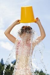 Italien, Südtirol, Mädchen (6-7) schüttet einen Eimer Wasser über ihren Kopf - WESTF13366