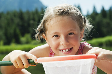 Italy, South Tyrol, Girl (6-7) holding net, portrait, close-up - WESTF13361