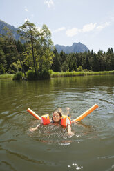 Italien, Südtirol, Mädchen (8-9) beim Schwimmen im See, lächelnd, Porträt - WESTF13358