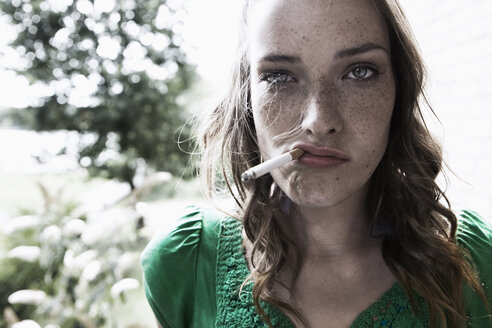 Deutschland, Berlin, Junge Frau raucht Zigarette, Porträt, Nahaufnahme - WESTF13450