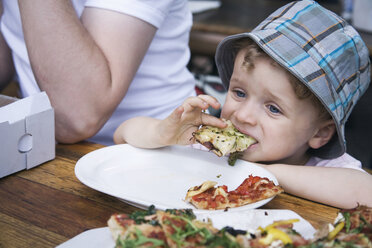 Deutschland, Berlin, Junge (3-4) isst Pizzastück im Freien, Porträt - WESTF13595
