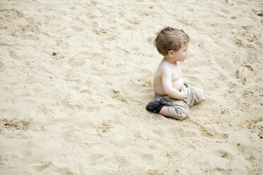 Germany, Berlin, Boy (2-3) sitting in sandbox - WESTF13589