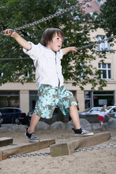 Germany, Berlin, Boy (3-4) at playground on suspension bridge - WESTF13567