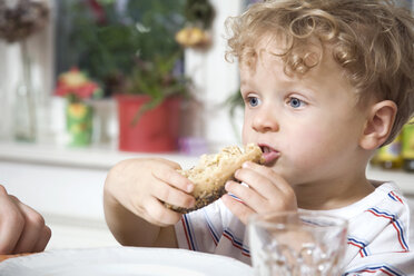 Germany, Berlin, boy (3-4) holding bread roll, portrait, close-up - WESTF13550