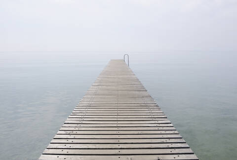 Italien, Steg am Gardasee im Nebel, lizenzfreies Stockfoto