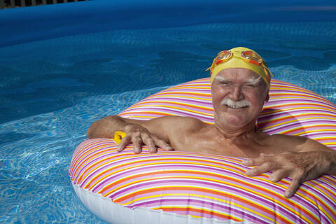 Österreich, Älterer Mann mit Schwimmreifen im Schwimmbad, lächelnd, Porträt, lizenzfreies Stockfoto